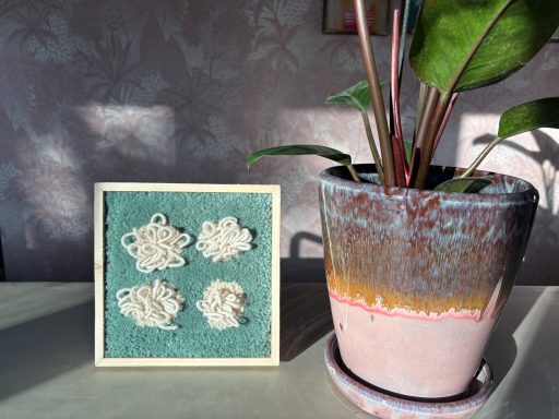Sophie Vierkant getuft schilderij van 22x22cm groen met 4 creme kleuroge wollige bolletjes erop.