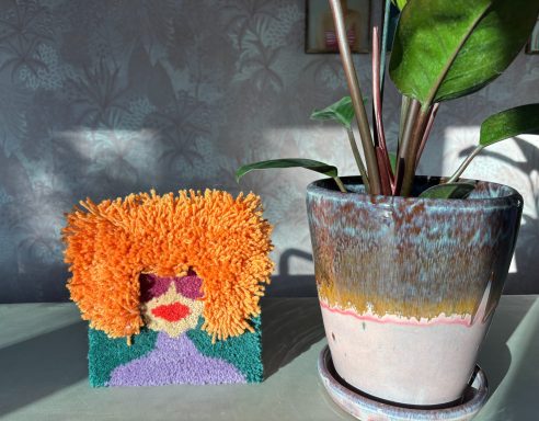 Mathilda tuftschilderij 20x20cm groene achtergrond met vrouw met bril en rare oranje haren