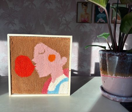 Suzie Een geftuft kunstwerk van een vrouw die een kauwgombel lucht uitblazend.